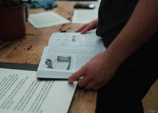 Hand flipping through a plant-science reference book